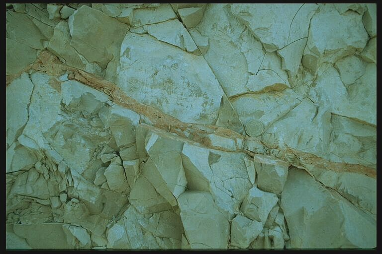 impact breccia dike cutting sharply through Jurassic limestone. Rubielos de la Cérida impact basin